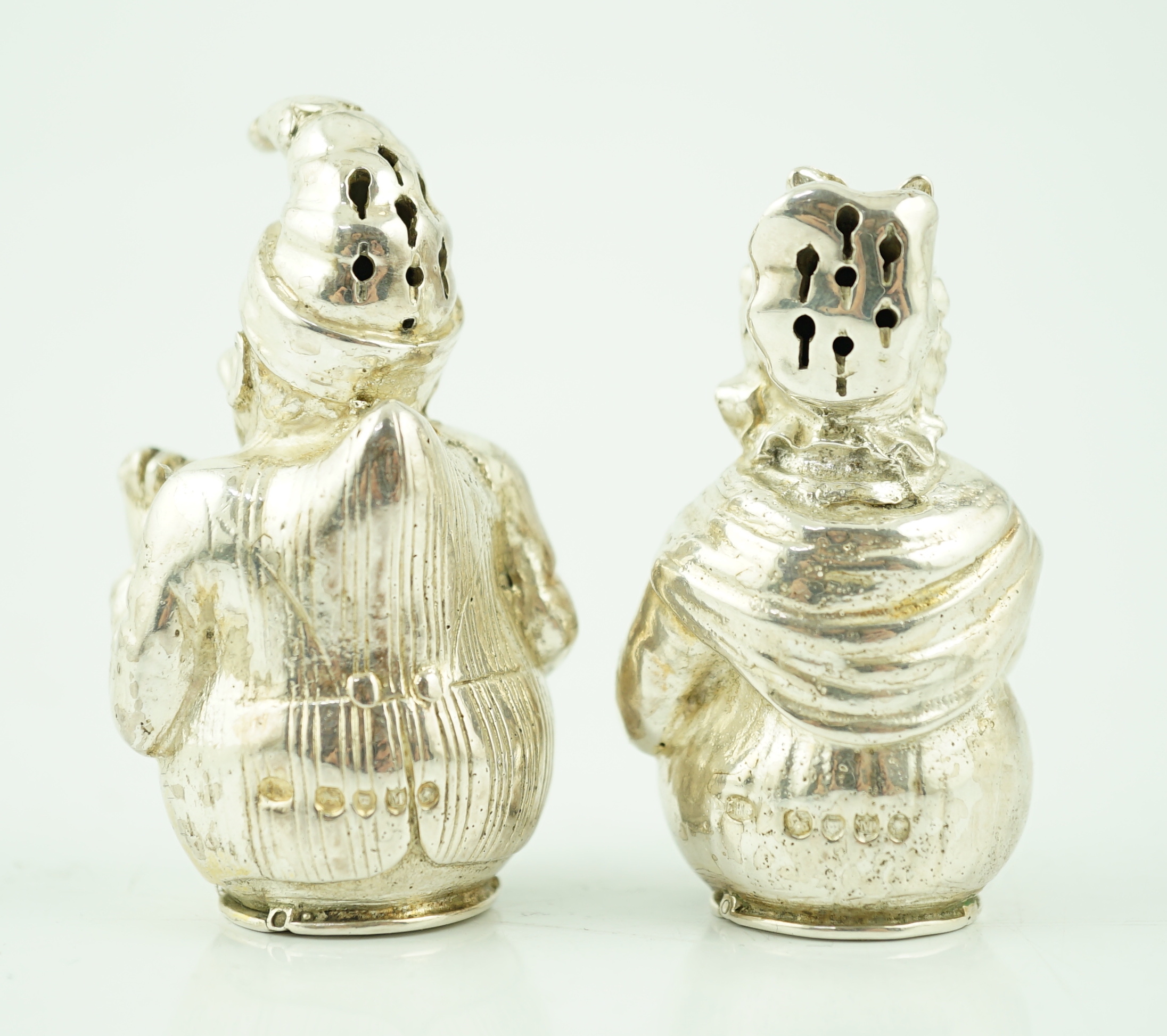 A pair of cast late Victorian novelty silver pepperettes, modelled as Punch and Judy, Edward H. Stockwell